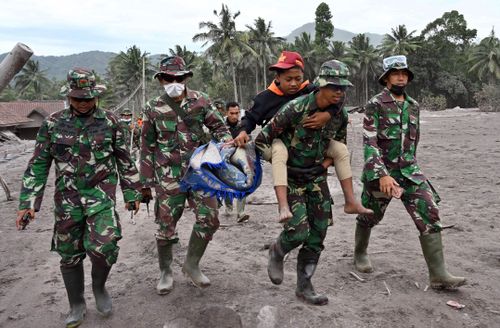 Members of a search and rescue team carry a villager during an operation in the village of Sumberwuluh after the volcano Mount Semeru erupted in Indonesia