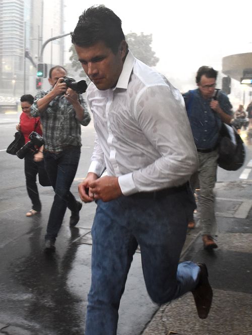 Rain and wind batter Gable Tostee as he runs from the Supreme Court in Brisbane on the day the jury retired to consider a verdict. (AAP Image/Dave Hunt) 