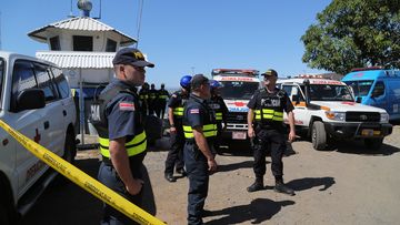 Costa Rican police and emergency workers wait for tourists rescued after a catamaran sank off the Pacific coast of Costa Rica. (AAP)
