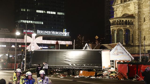 Police officers stand beside a truck which ran into a crowded Christmas market and killed several people in Berlin, Germany. (AAP)