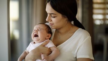 Newborn baby crying in mother hands