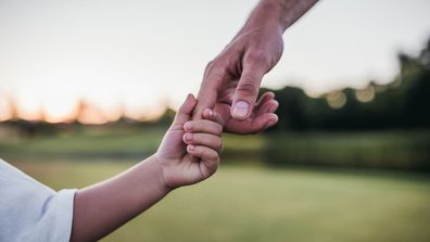 Dad holding child's hand