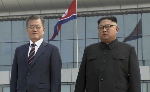 South Korean President Moon Jae-in, left, poses with North Korean leader Kim Jong-un for a photo on the podium upon arrival in Pyongyang.