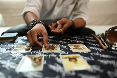 Fortune teller arranging tarot cards on the desk. Forecasting and fortune telling concept.