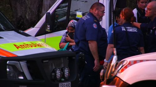 NSW Ambulance workers treat family members after yesterday's tragic events.