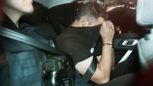 Fugitive Jonathan Dick is driven into Police Headquarters after his arrest in Melbourne.