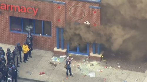 Footage showed protesters looting the store before it was set on fire. (9NEWS)