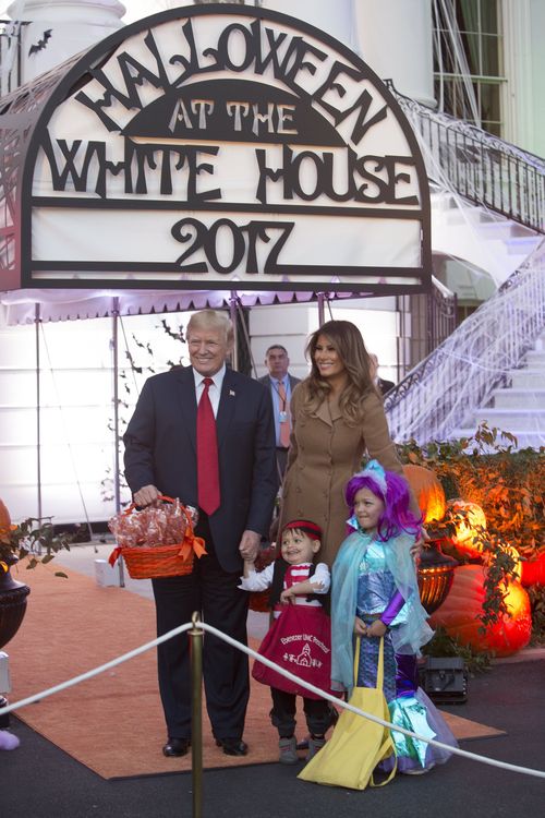 US President Donald J. Trump and First Lady Melania Trump pose for photos while giving out treats during a Halloween event at The White House. (AAP)