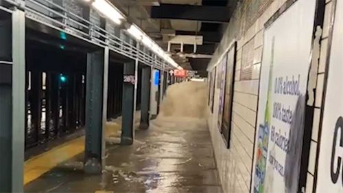 Floodwaters gush into a New York subway station.