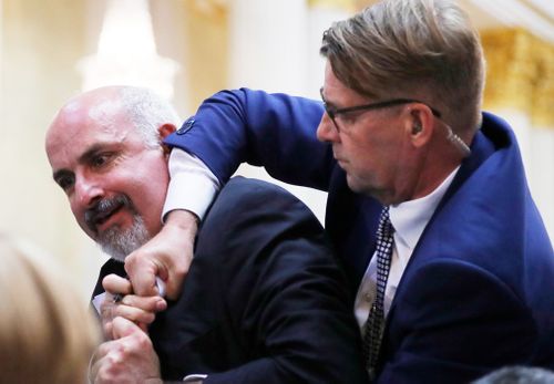 A US Secret Service agent spoke with the unidentified man, before Finnish security physically escorted him from the room. Image: AP