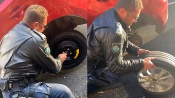 Cop helps change flat tyre