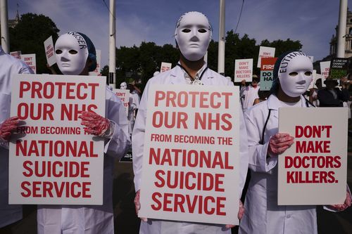 Demonstrators for assisted dying hold banners outside Parliament in London, Friday, June 20, 2025