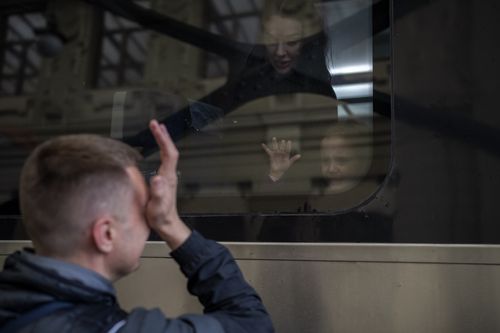 Ukrainian Nicolai, 41, cries as he says goodbye to his daughter Elina, 4, and his wife Lolita, on a train bound for Poland fleeing from the war at the train station in Lviv, western Ukraine, Friday, April 15, 2022. (AP Photo/Emilio Morenatti)