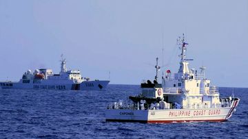 A Chinese Coast Guard ship sails near a Philippine Coast Guard vessel during its patrol at Bajo de Masinloc, on March 2.