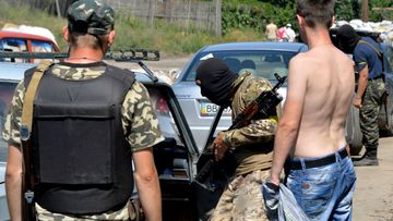 Ukrainian troops search passing cars at at a checkpoint near the eastern Ukrainian city of Lisichansk. (Getty Images)