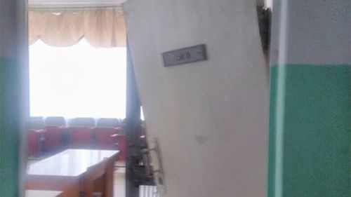 The courtroom door hangs off one hinge following the dual grenade blasts. (Image: Ukrainian Police Facebook)