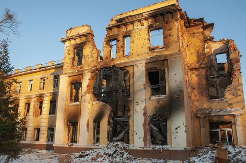 A damaged by shelling building is lit by sunset in Kharkiv, Ukraine, Friday, March 11, 2022