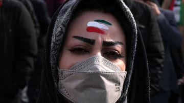 A woman with forehead painted with the Iranian flag&#x27;s colors takes part in the annual rally commemorating Iran&#x27;s 1979 Islamic Revolution