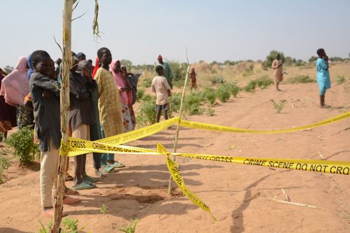 People stand behind crime scene tape at the site of a U.S. airstrike in Northwest, Jabo, Nigeria, Friday, Dec. 26, 2025. (AP Photo/ Tunde Omolehin)