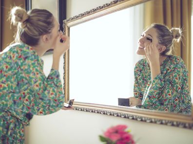 Woman getting ready in front of mirror
