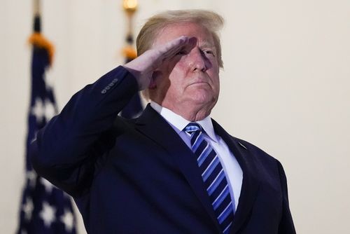 President Donald Trump salutes to Marine One as he stands on the balcony outside of the Blue Room as returns to the White House 