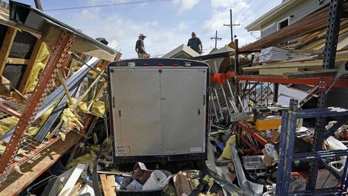 Jacob Hodges, right, and his brother Jeremy Hodges work to clear debris from their storage unit which was destroyed by Hurricane Ida.