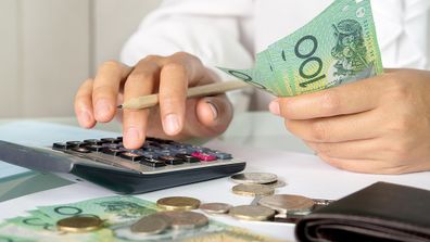 Australian woman doing her budget with calculator