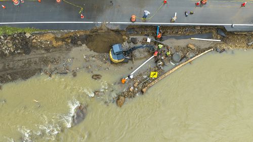 Volunteers and city workers try to reconnect the water supply to a nursing home in Elkhorn City, Ky., on Friday, July 29, 2022. The pipe, along with some of KY-197, washed away yesterday when the Russell Fork flooded. (Ryan C. Hermens/Lexington Herald-Leader via AP)