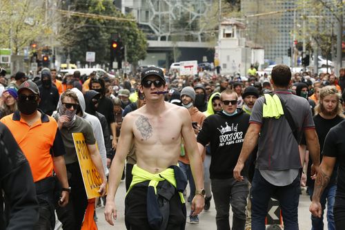 MELBOURNE, AUSTRALIA - SEPTEMBER 22: Protesters walk down Swanston Street in the CBD on September 22, 2021 in Melbourne, Australia. Protests started on Monday over new COVID-19 vaccine requirements for construction workers but  turned into larger and at times violent demonstrations against lockdown restrictions in general. Melbourne is currently subject to COVID-19 lockdown restrictions, with people only permitted to leave home for essential reasons. (Photo by Darrian Traynor/Getty Images)