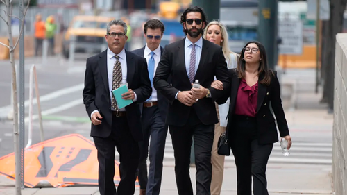 Lawrence Rudolph's defense investigator, left, heads into federal court in Denver along with the dentist's children in 2022.