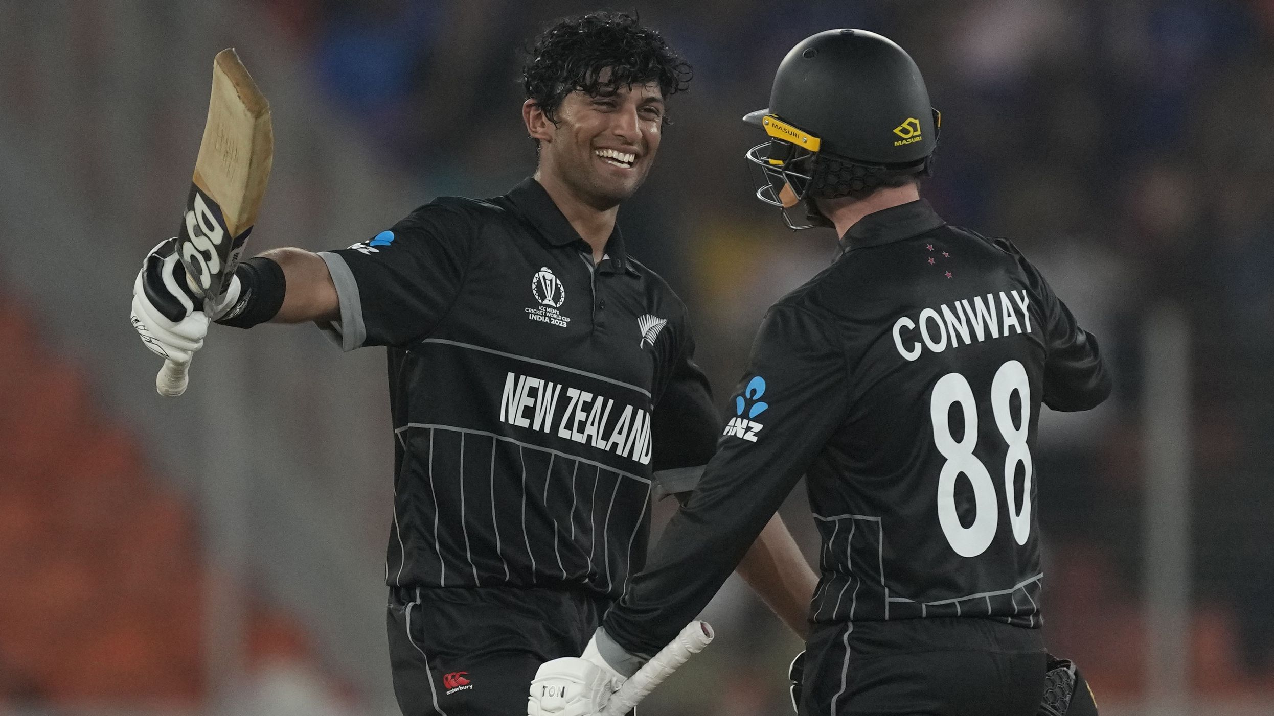 New Zealand&#x27;s Rachin Ravindra celebrates his century with teammate Devon Conway.