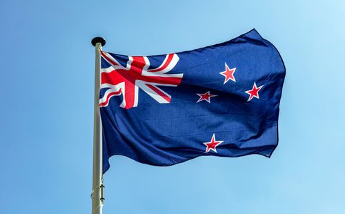 Bandeira da Nova Zelândia, símbolo nacional da Nova Zelândia acenando contra o céu azul claro, dia ensolarado