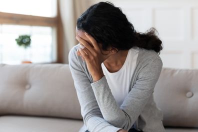 Sad woman sitting on couch