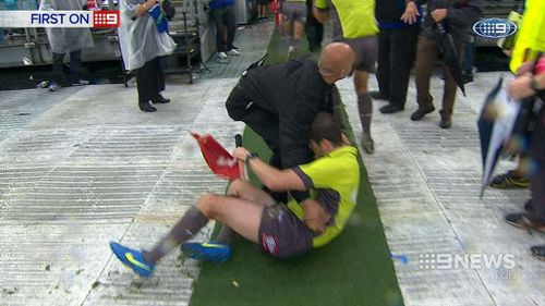 Sideline interchange official Darren Alchin suffered a broken  shoulder during the incident. (9NEWS)