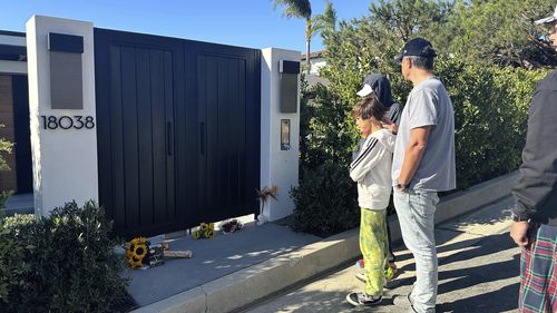 Mourners stand outside the home of actor Matthew Perry, Sunday, Oct. 29, 2023, in the Pacific Palisades area of Los Angeles. 