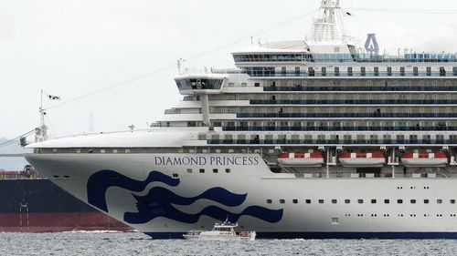 A small boat navigates near a cruise ship Diamond Princess anchoring off the Yokohama Port in Yokohama, near Tokyo. 