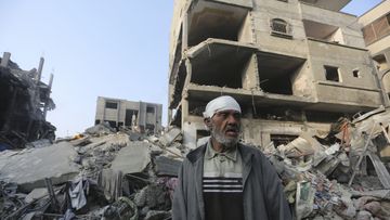 A Palestinian stands outside the building destroyed in the Israeli bombardment of the Gaza Strip