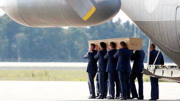A coffin containing more remains from the MH17 crash site touches down in the Netherlands. (AAP)