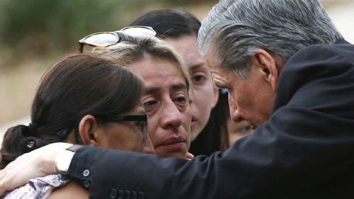 The archbishop of San Antonio, Gustavo Garcia-Siller, right, comforts families outside the Civic Center following a deadly school shooting at Robb Elementary School in Uvalde, Texas.