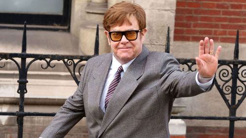 Elton John salue devant la cour royale de justice de Londres, en Angleterre