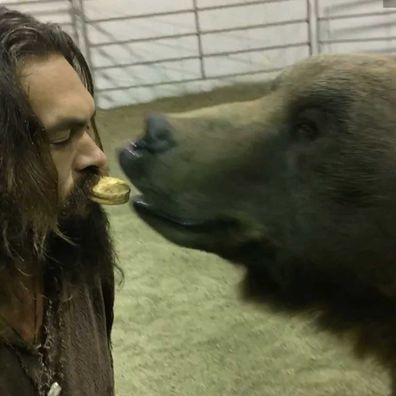 Jason Momoa lets a bear eat an oreo out of his mouth on the set of his new show, See.