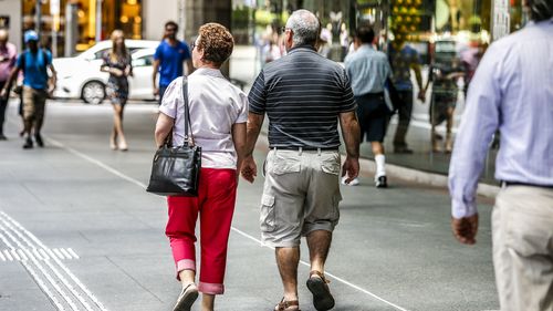 Two old people walk down the street in Brisbane