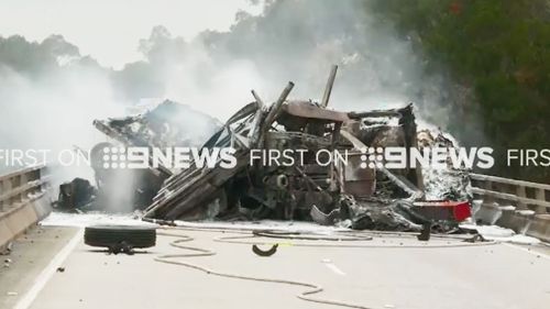 Crews work to clean up the burnt out wreckage. (9NEWS)