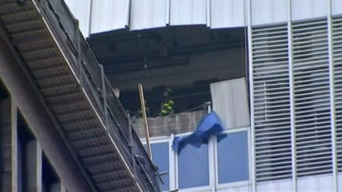 The falling unit smashed into the building on its descent. (9NEWS)