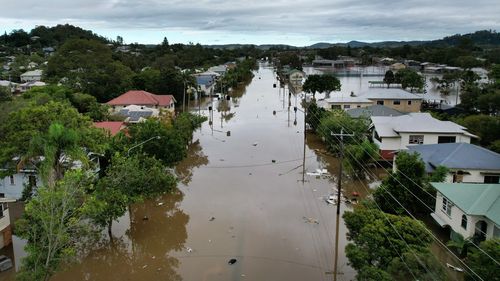An aerial drone view of houses surrounded by floodwater in Lismore, NSW