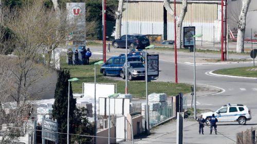 Heavily armed police swarm the supermarket. (AP/AAP)