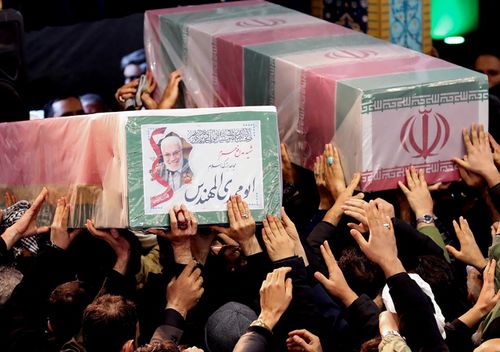 Iranian mourners carrying caskets of slain Iranian military commander Qasem Soleimani (L) and Iraqi paramilitary chief Abu Mahdi al-Muhandis at Tehran University in the Iranian capital