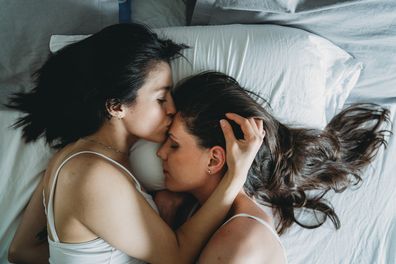 Two young adult women kissing
