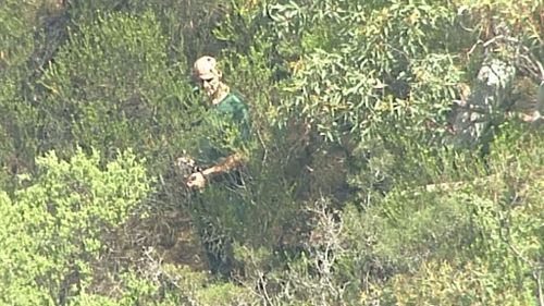 Aerial footage appears to show the accused leading detectives through NSW bushland. (9NEWS)