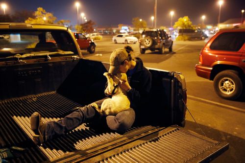 Paradise teacher Sarah Gronseth kisses her dog Branch while resting in the bed of a truck.